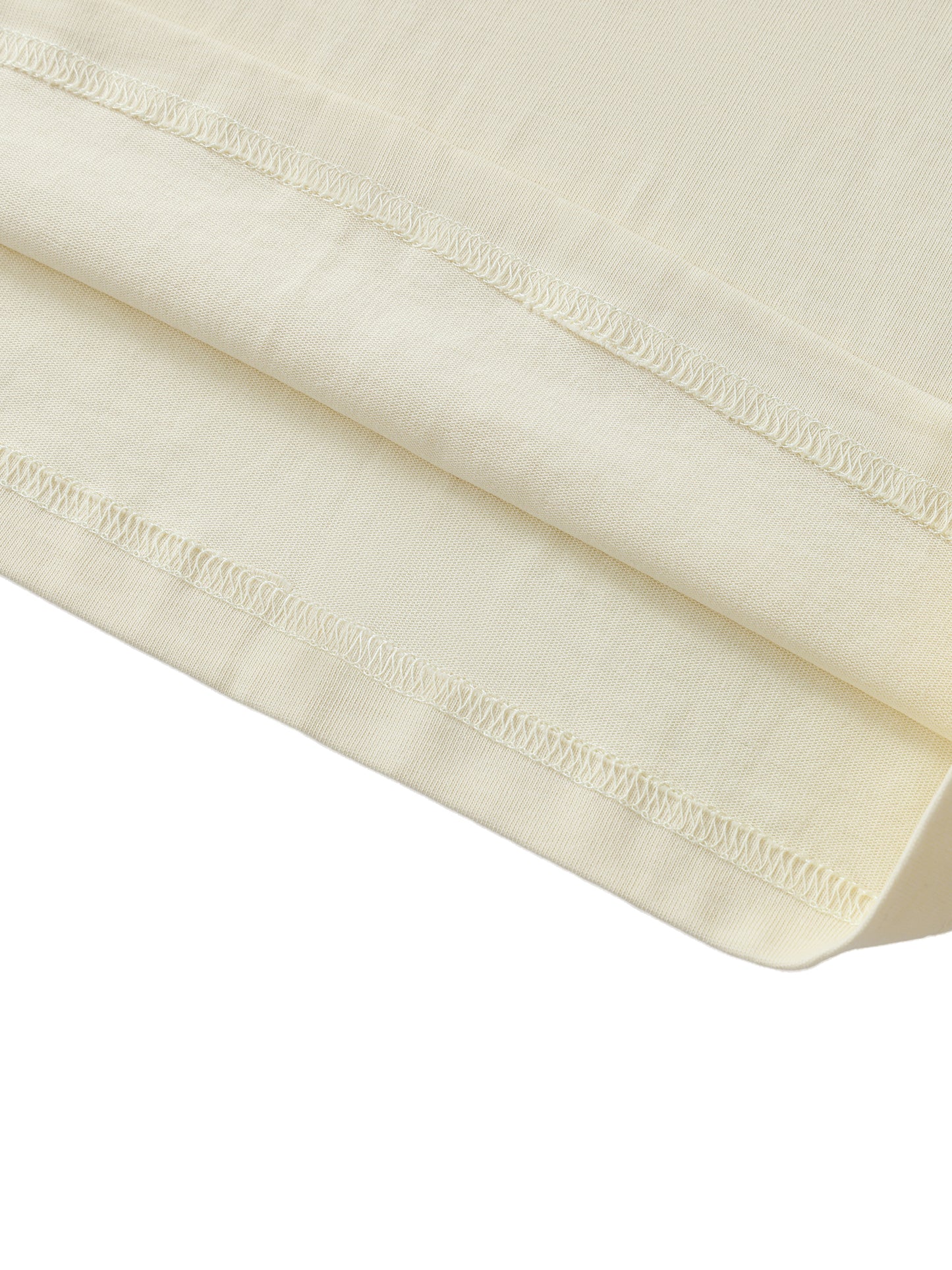 Close-up of a folded cream-colored fabric with visible stitching on a white background