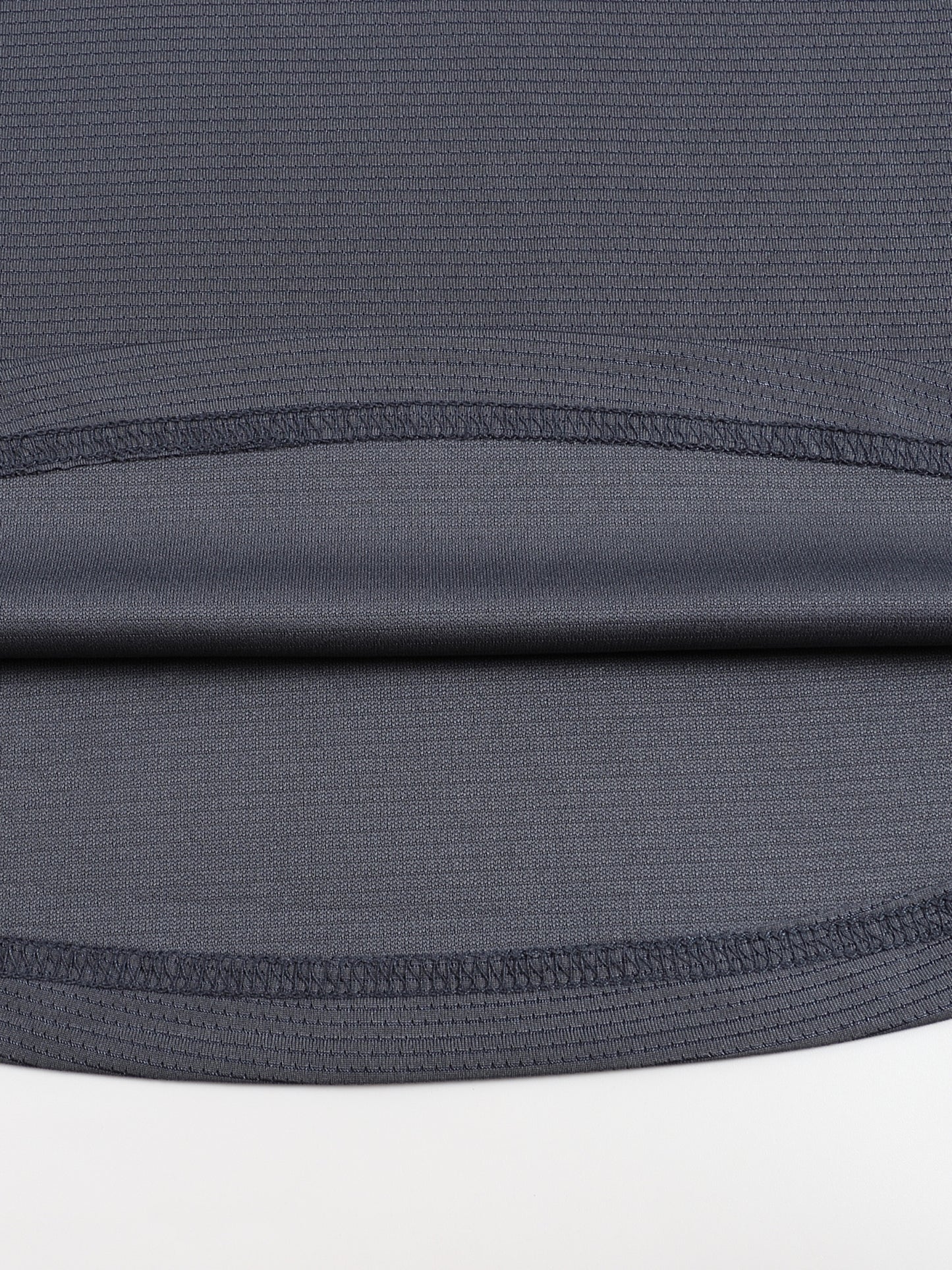 Close-up of a dark gray fabric with a subtle pattern on a white background