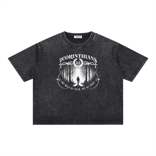 Black t-shirt with white graphic design containing the words "2 corinthians" "we walk by faith, not by sight." with a graphic of a person wondering the woods on a white background.
