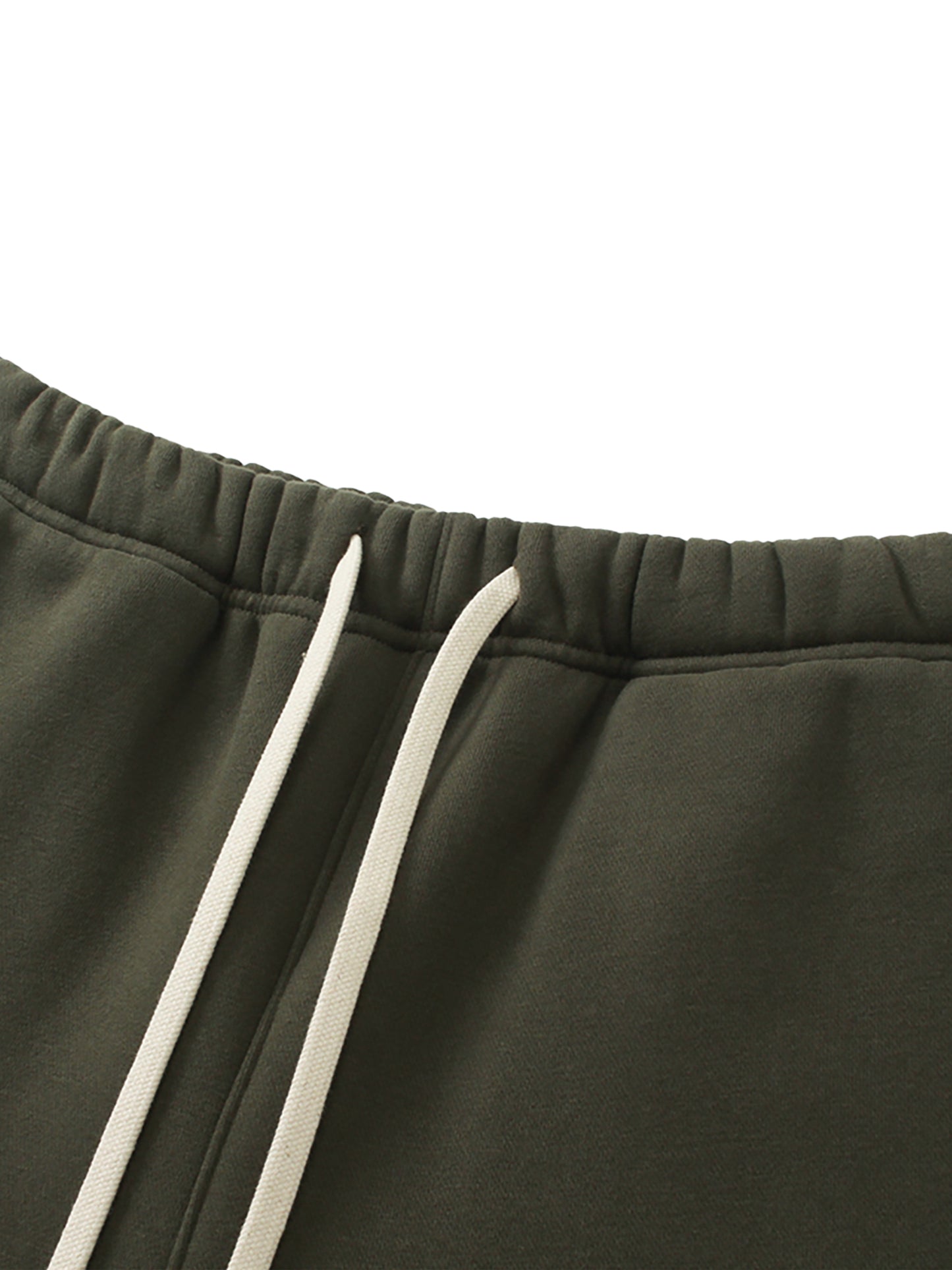 Close-up of dark green sweatpants with white drawstring on a white background