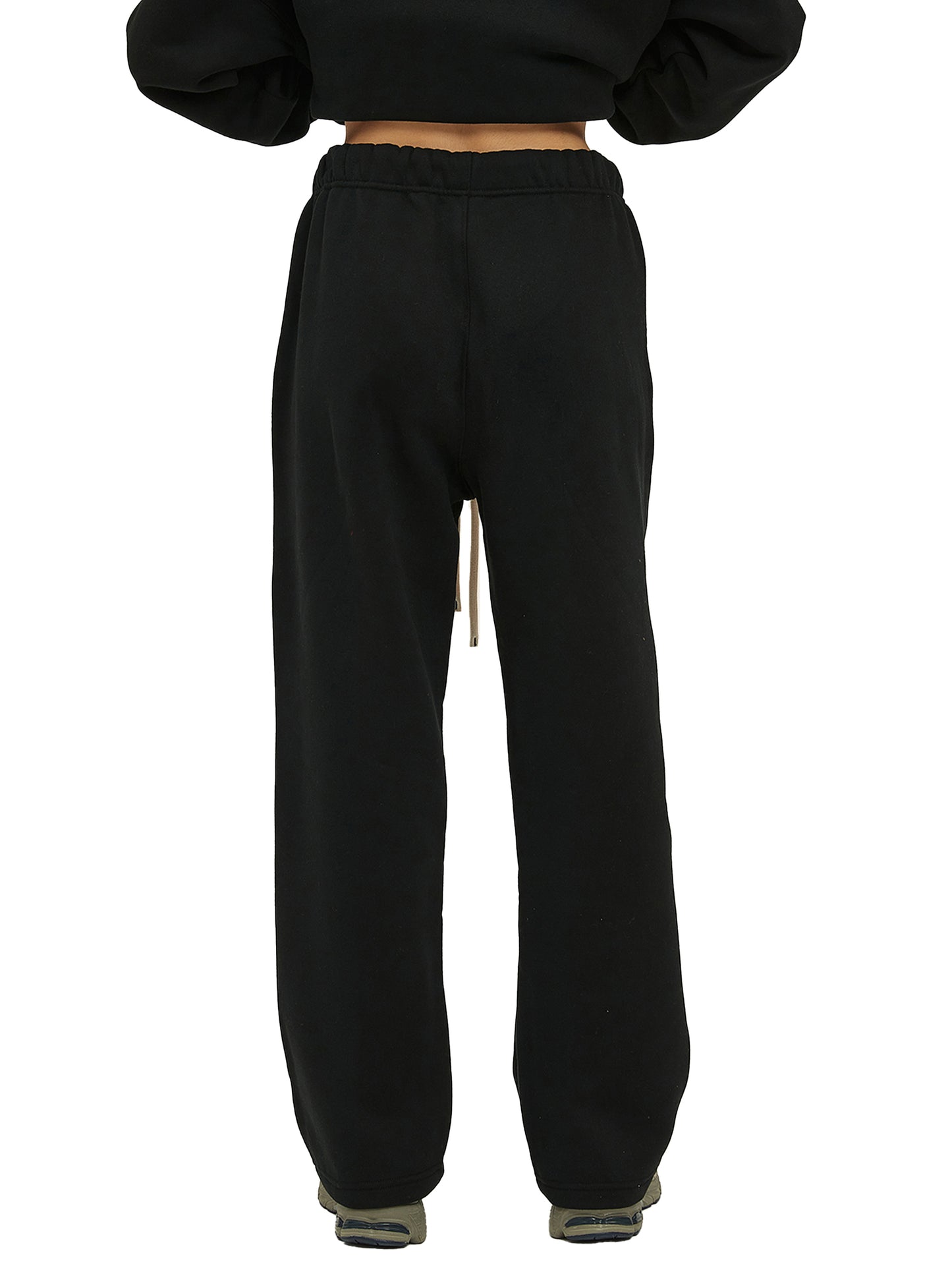 Black sweatpants worn by a person on a white background