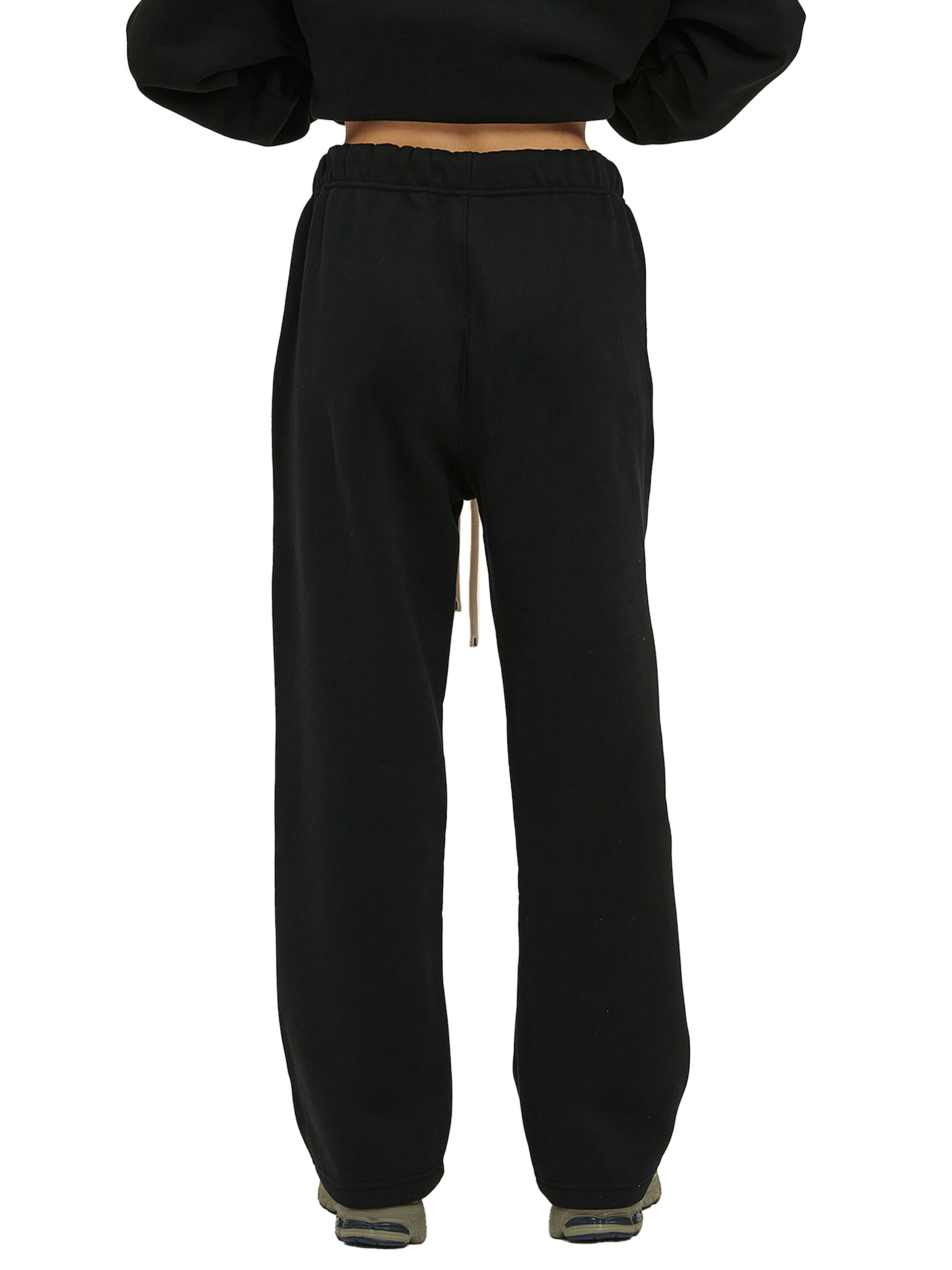 Black sweatpants worn by a person on a white background