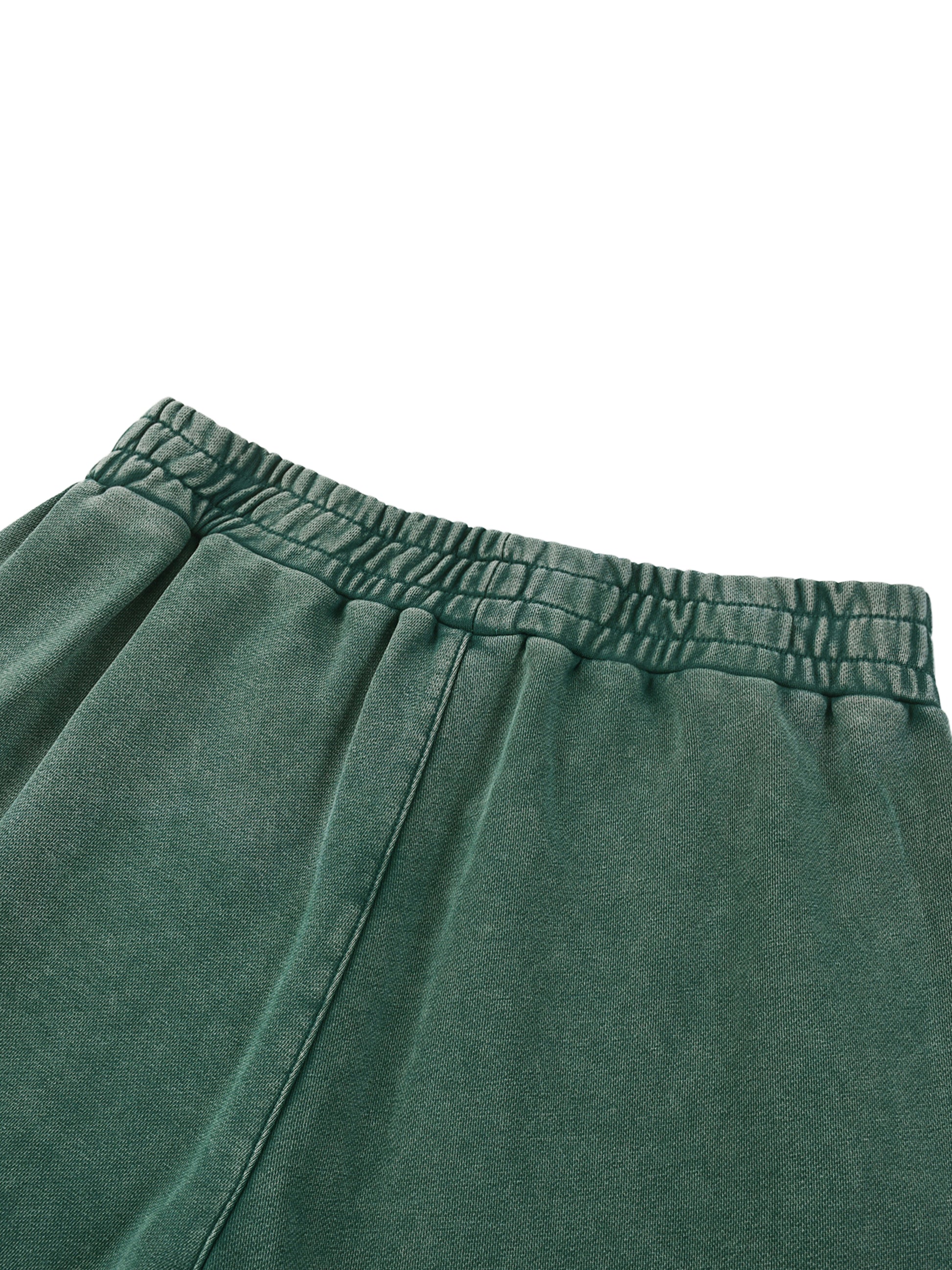 Close-up of green sweatpants with an elastic waistband on a white background