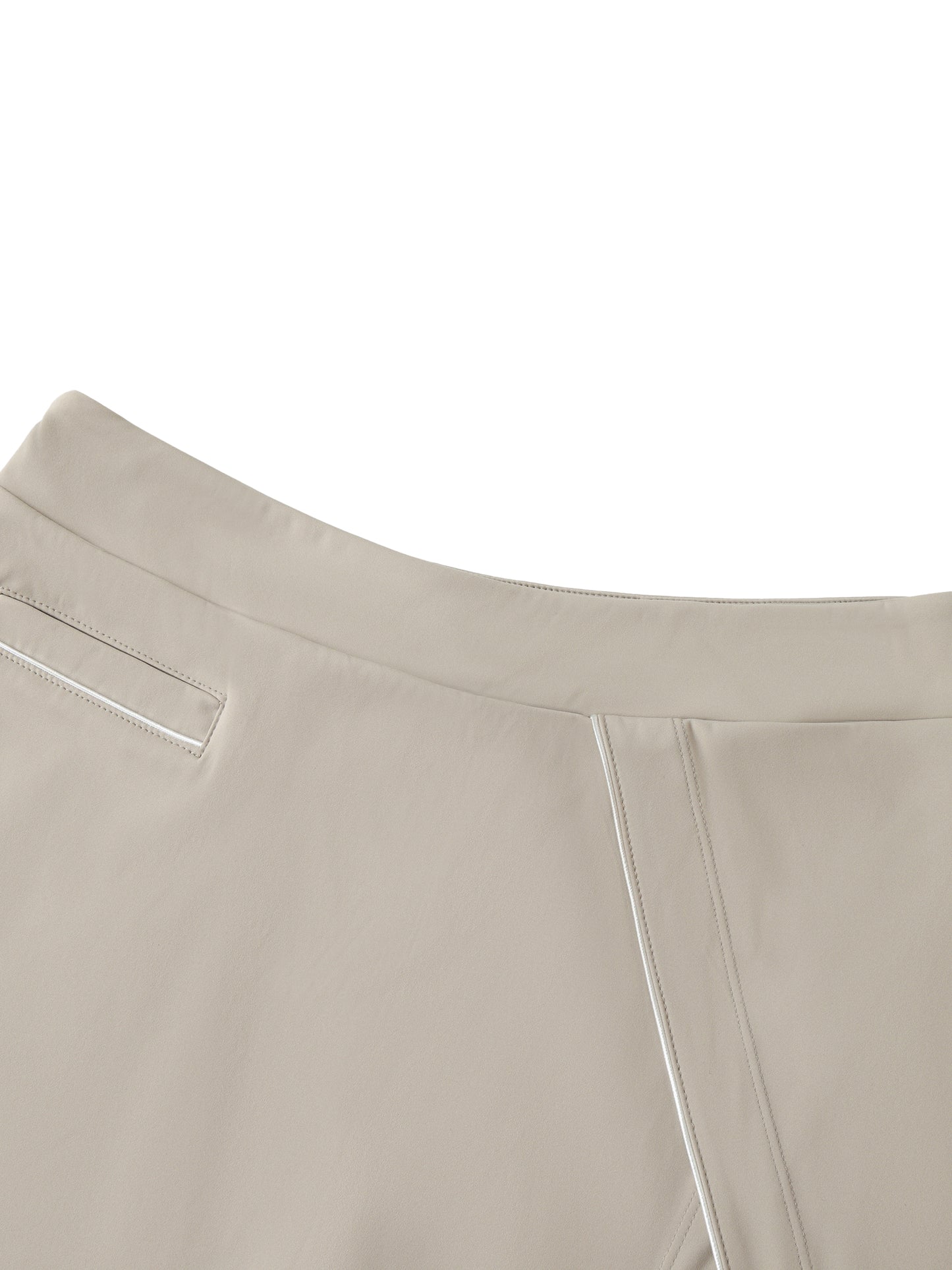 Close-up of beige skirt with white stitching in front of a white background