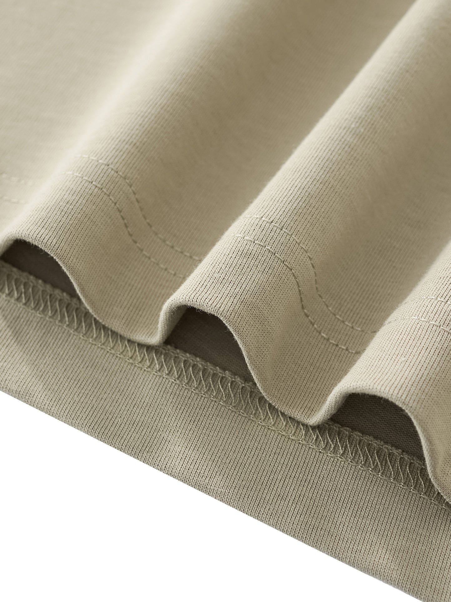 Close-up of beige fabric with stitching detail on a white background