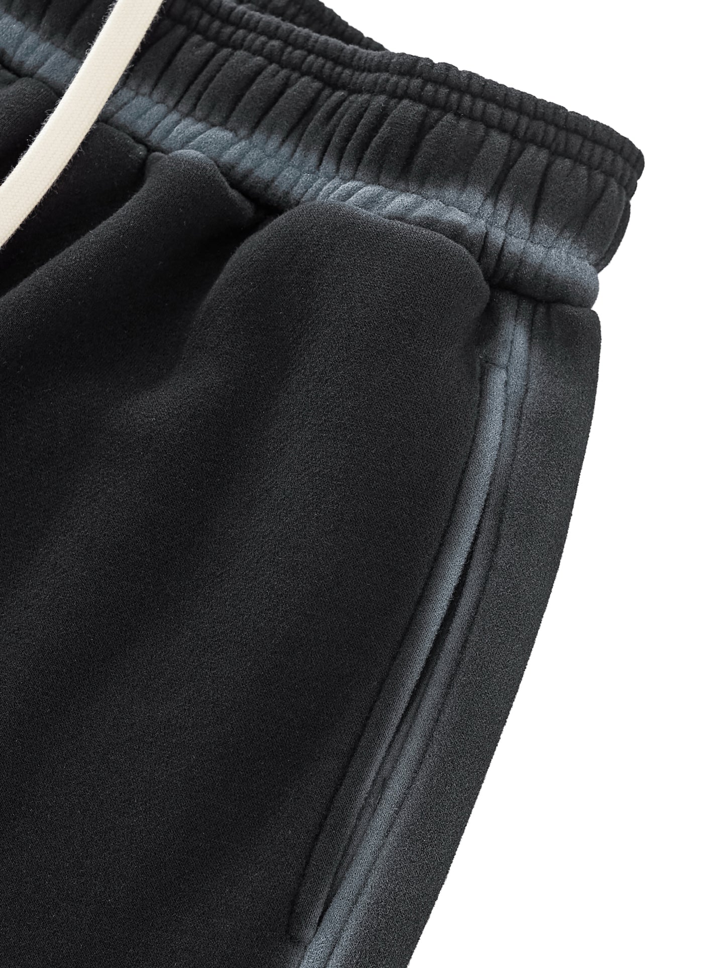Close-up of dark gray sweatpants with a white waistband on a white background