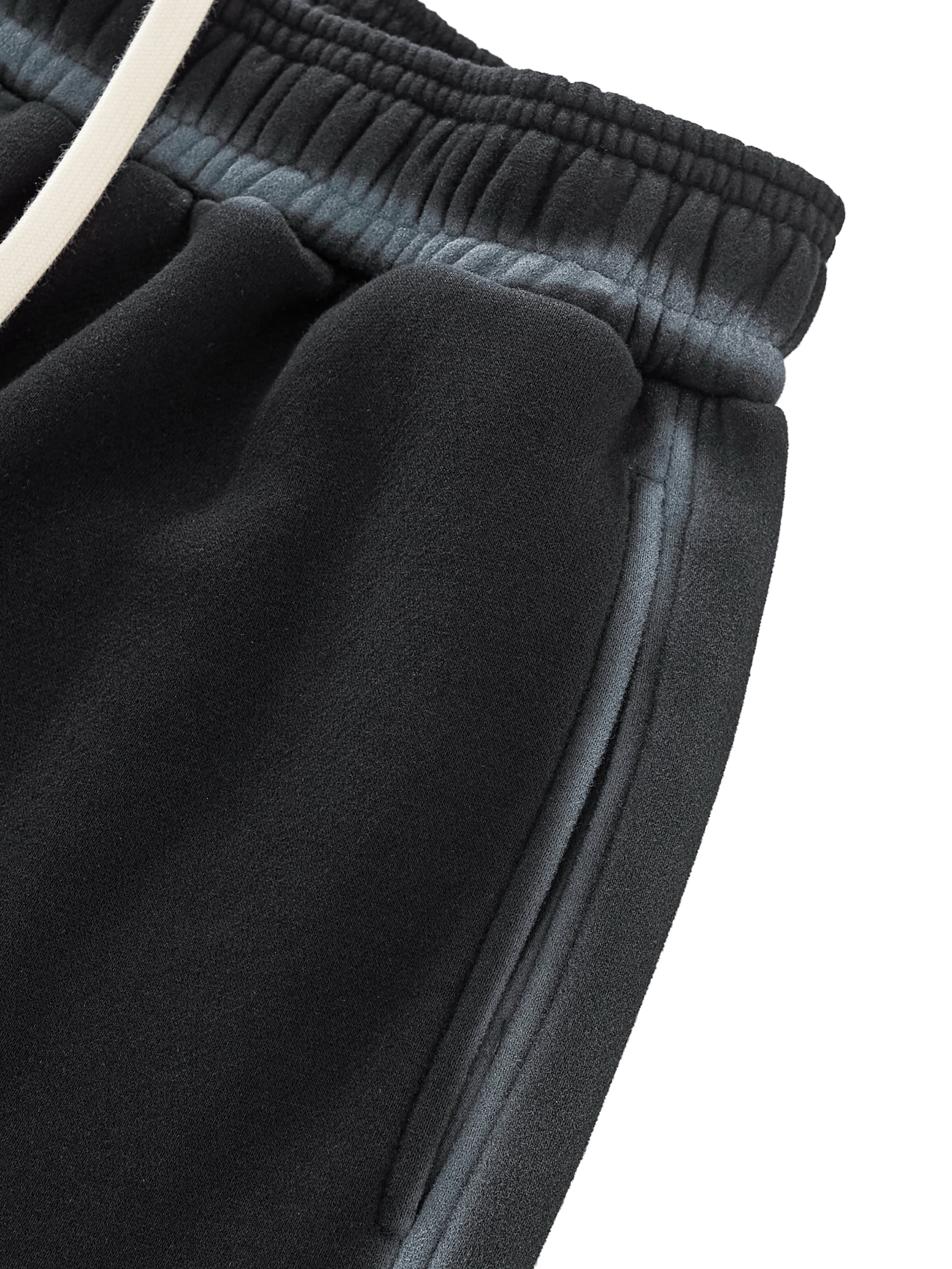 Close-up of dark gray sweatpants with a white waistband on a white background