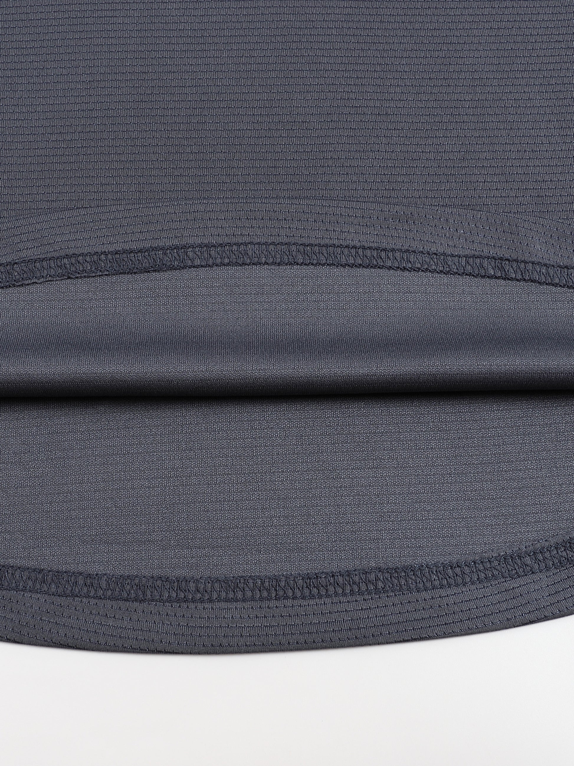 Close-up of a dark gray fabric with a subtle pattern on a white background