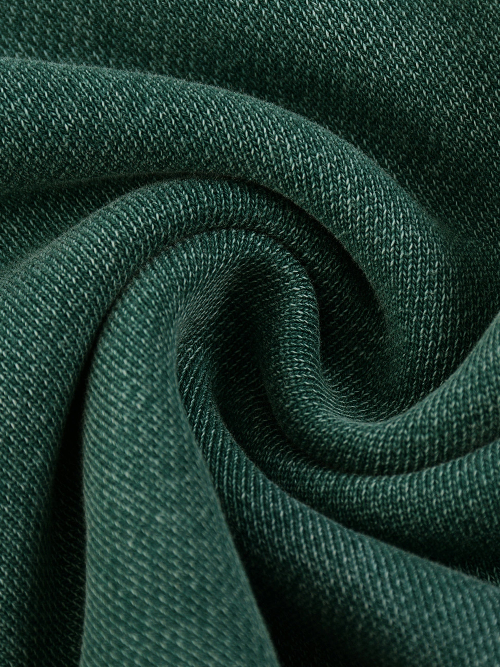 Close-up of dark green fabric with a textured pattern