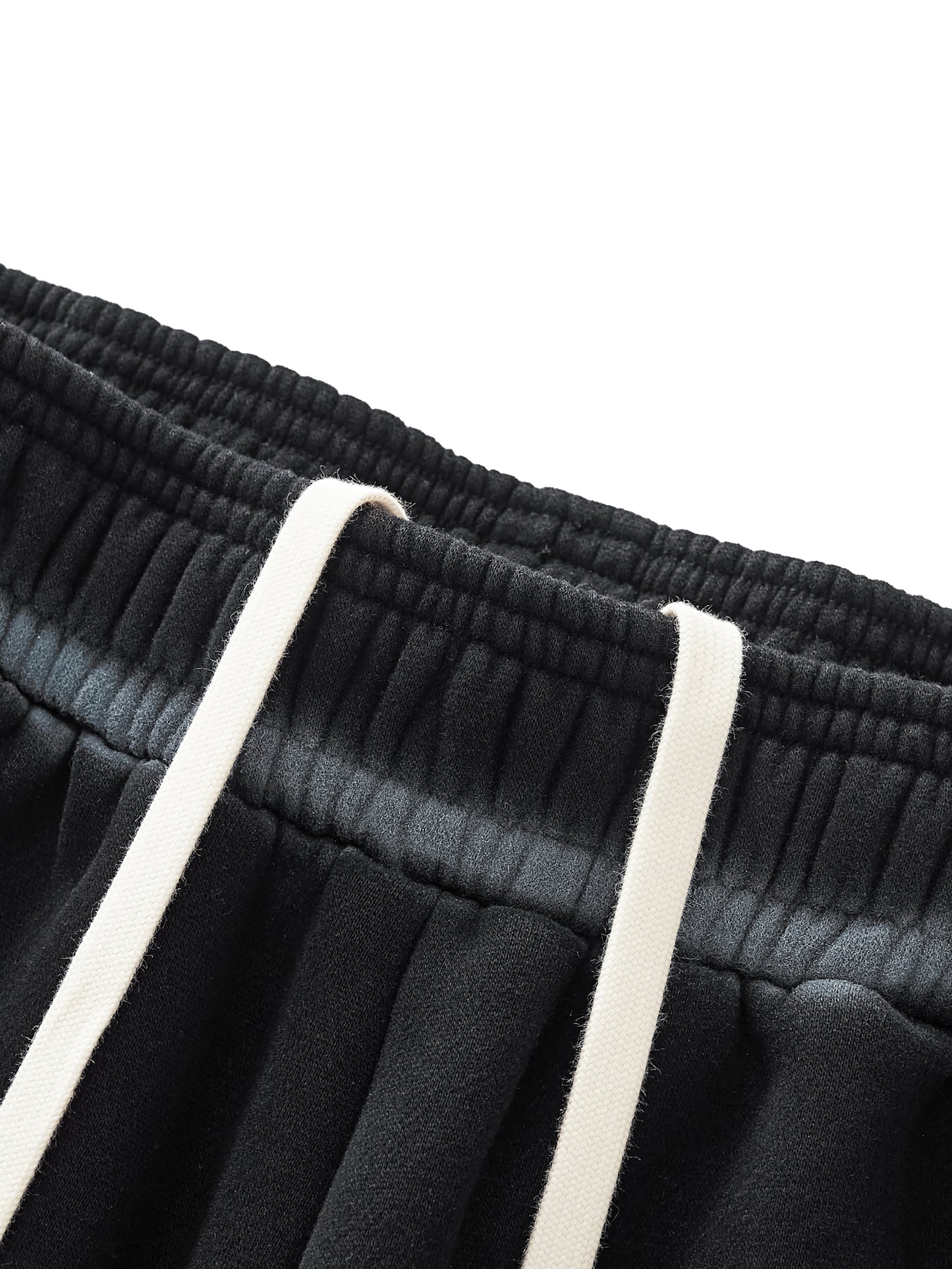 Close-up of black pants with white drawstrings on a white background
