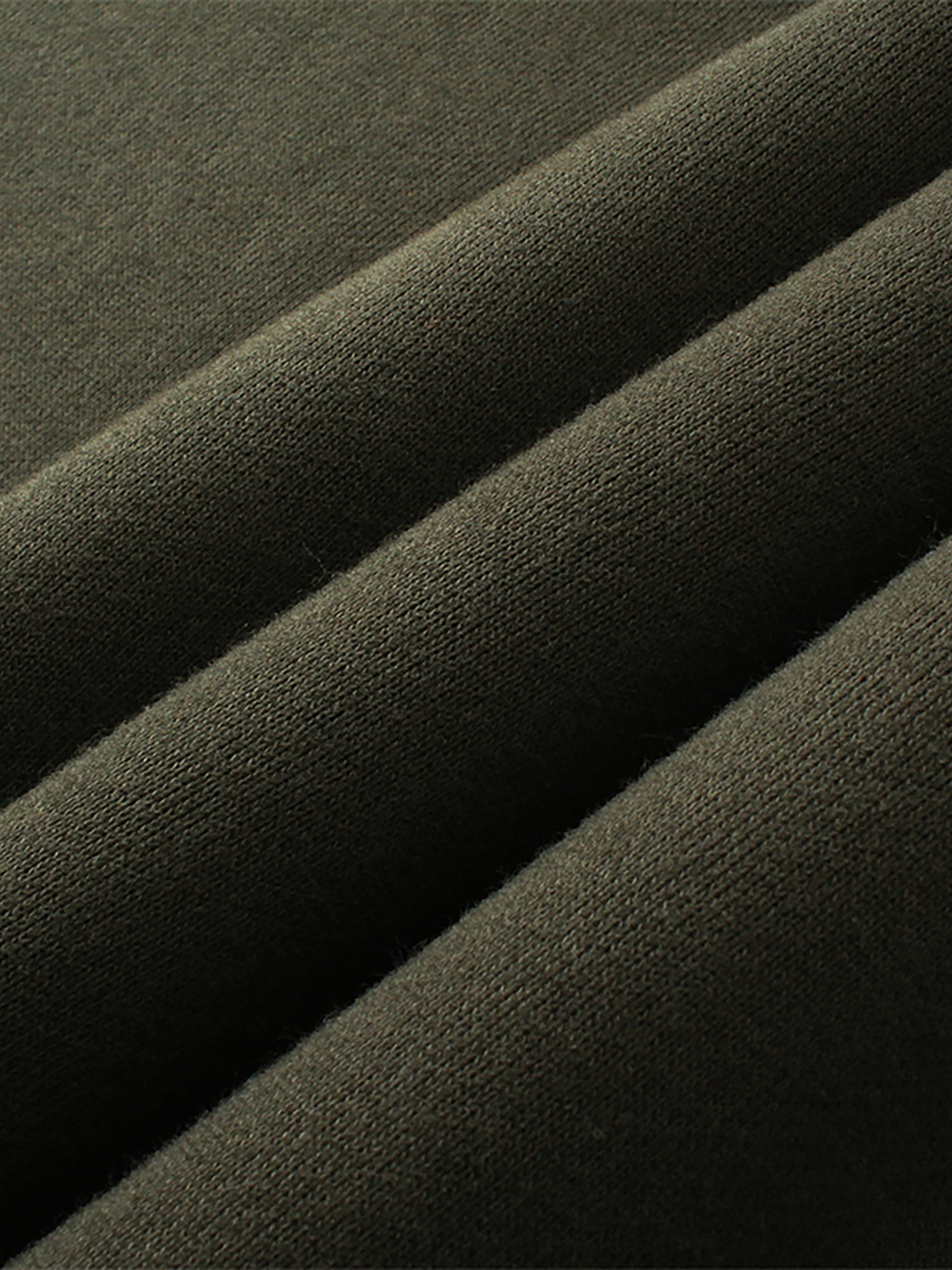 Close-up of dark green fabric with folds
