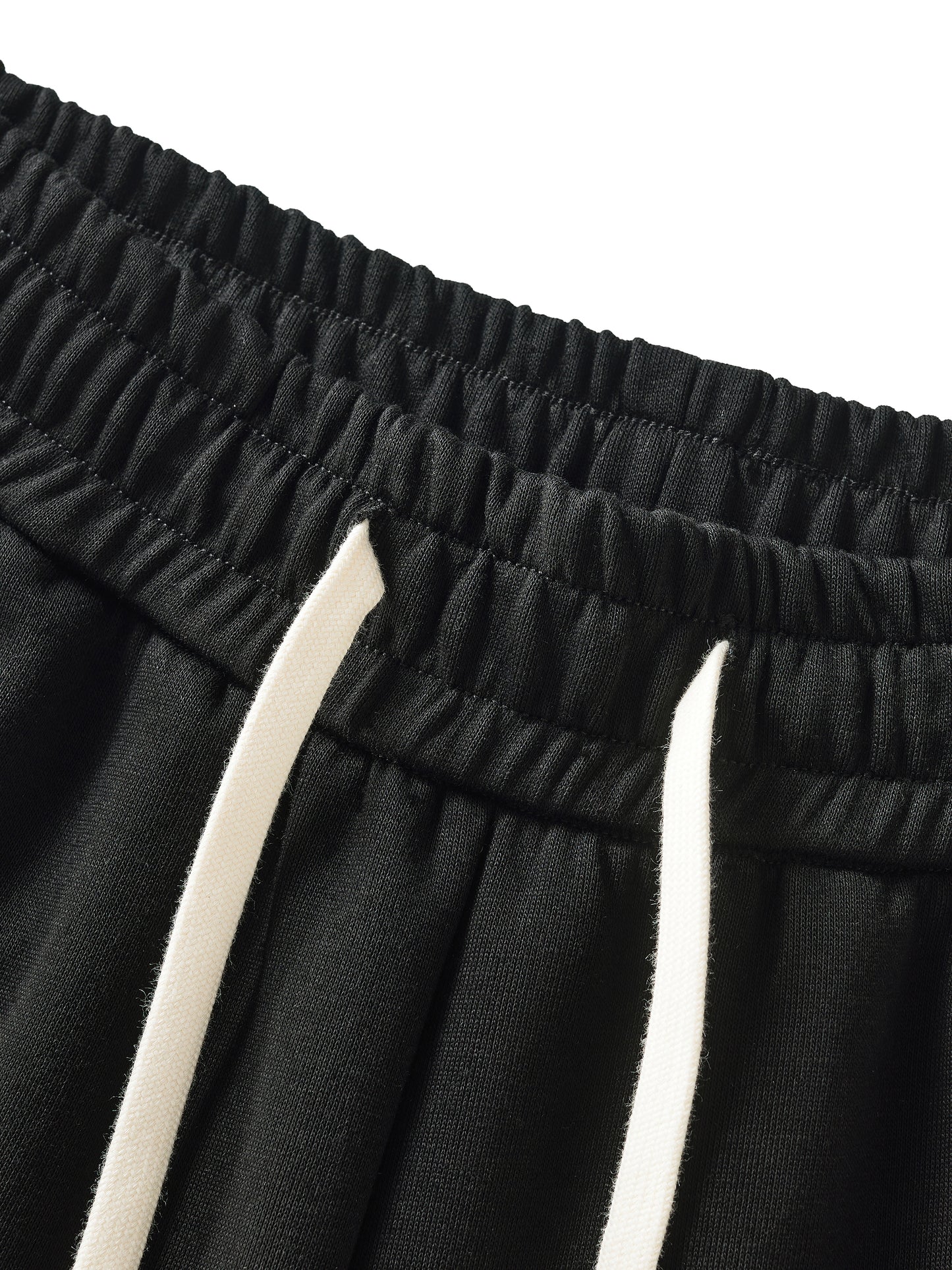 Close-up of black shorts with white drawstring on a white background