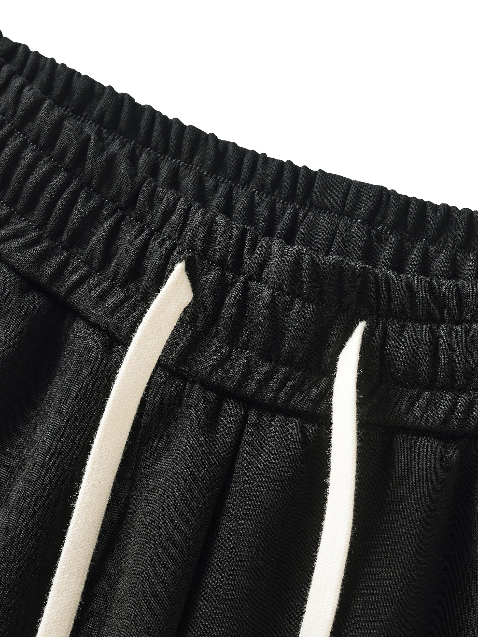 Close-up of black shorts with white drawstring on a white background
