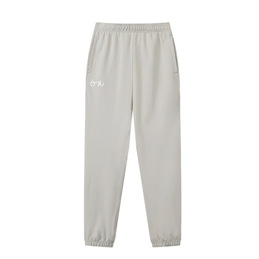 Front of oat gray cuffed sweatpants/joggers with an oa logo in white in front of a white background.