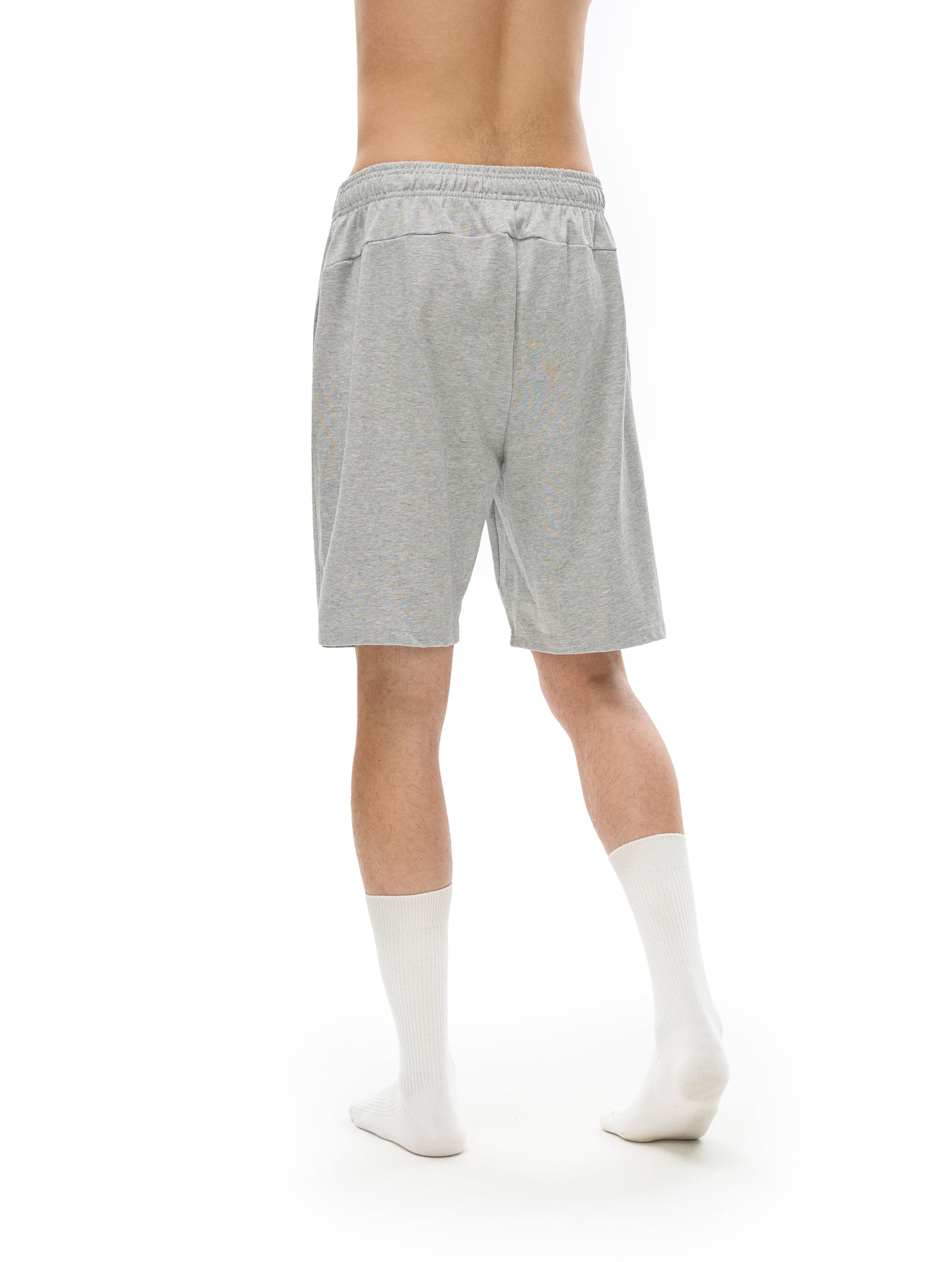 Person wearing gray shorts and white socks on a white background