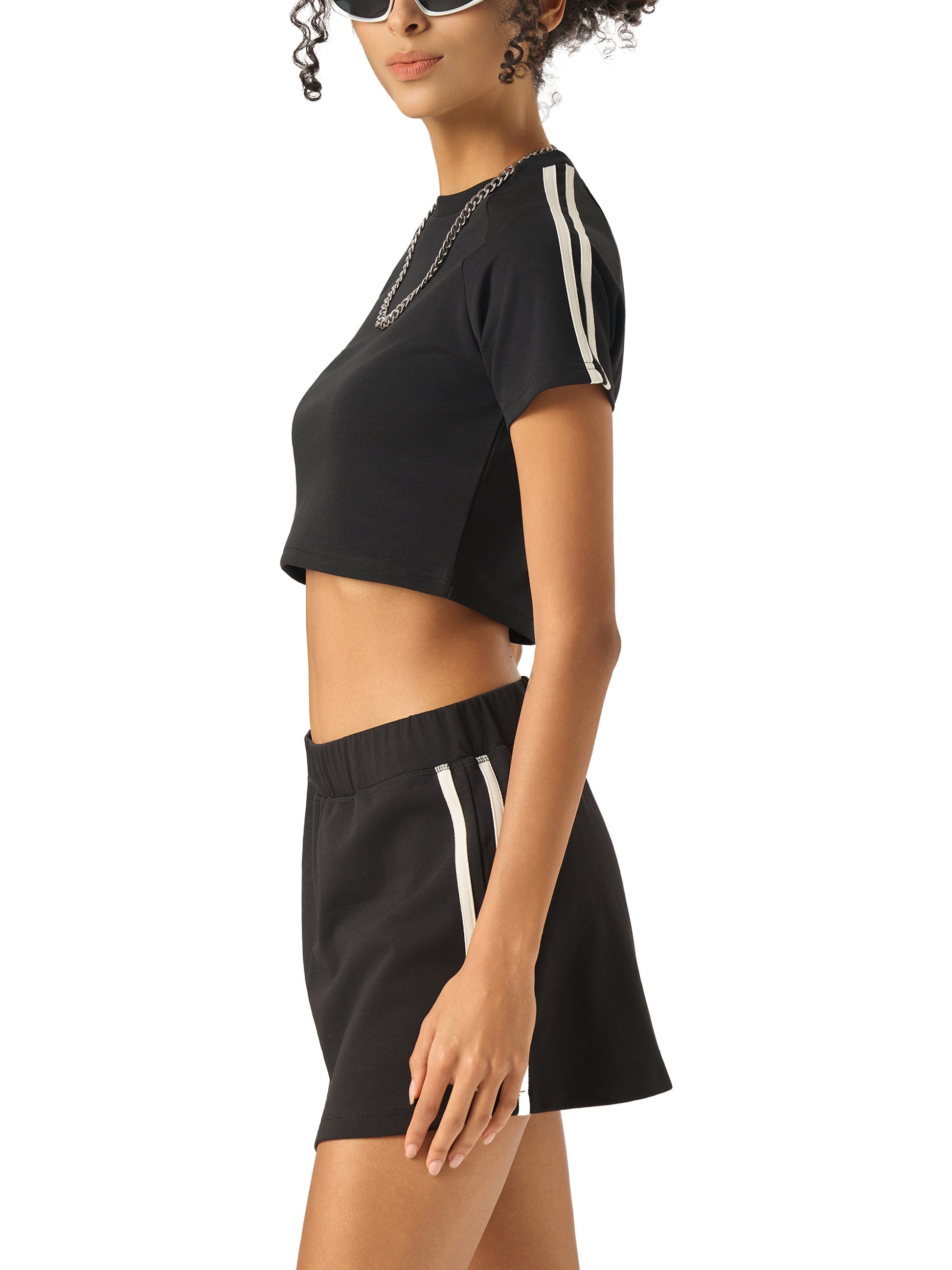Woman wearing a black outfit with white stripes on a white background