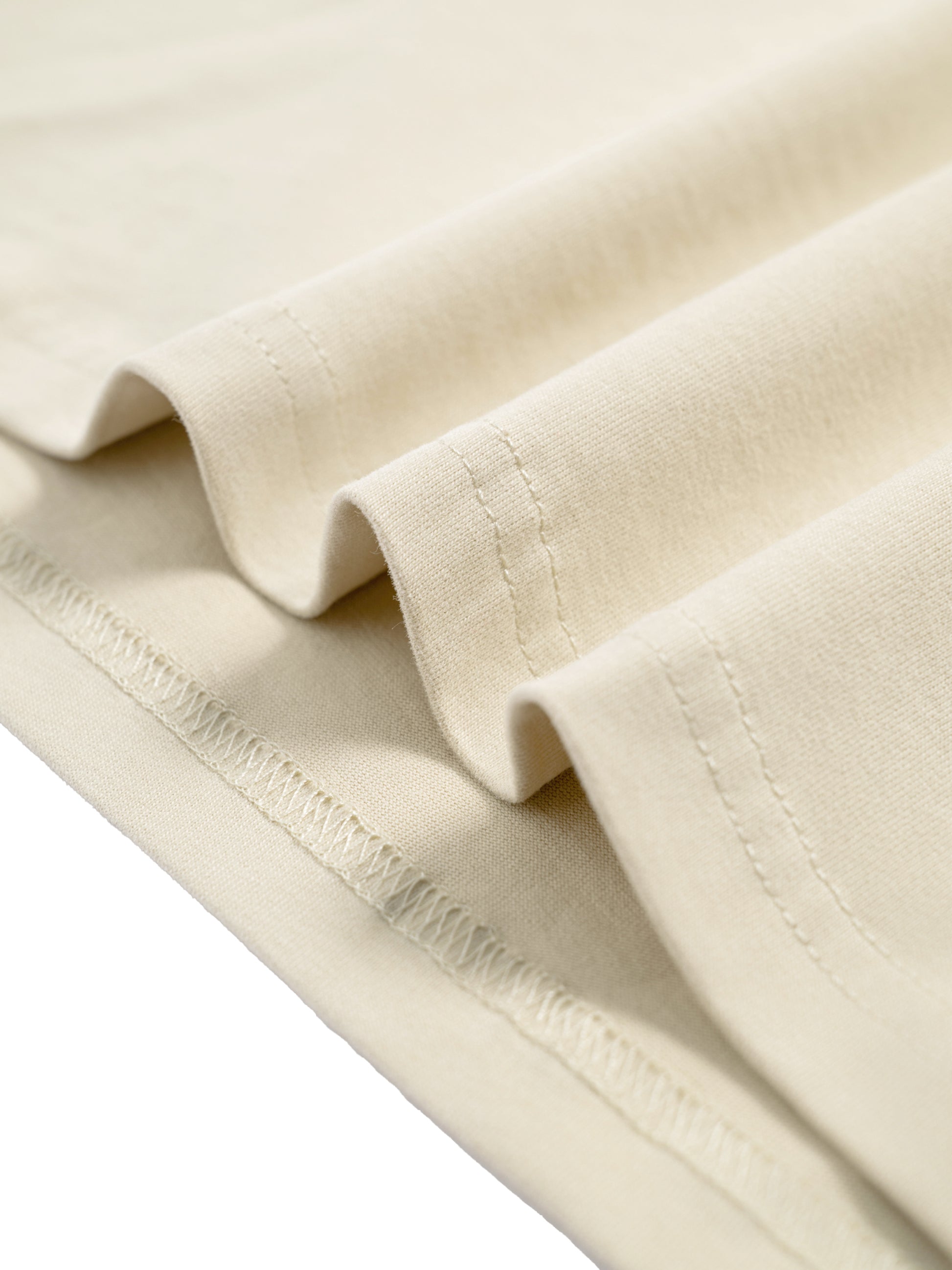 Close-up of beige fabric with visible stitching on a white background